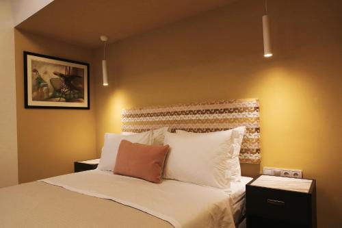 a bedroom with a bed with white pillows at Absolute Athens Acropolis Muses in Athens