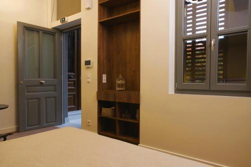 a hallway with a door and a window with wine bottles at Absolute Athens Acropolis Muses in Athens
