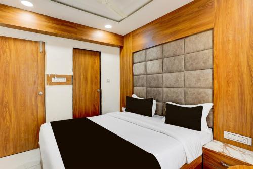 a bedroom with a large bed and wooden walls at Hotel O Dream Space in Ahmedabad