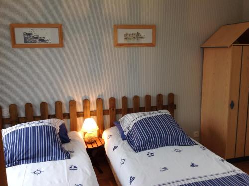 een slaapkamer met twee eenpersoonsbedden en een lamp bij L'Orchard in Bonneville-la-Louvet