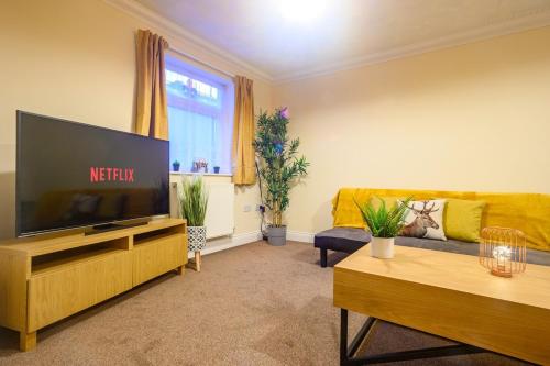 a living room with a television and a couch at Merriotts Court - Parking - WIFI in Newport