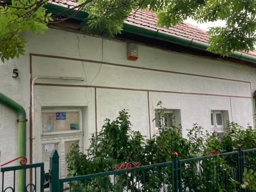 a white house with a window and a fence at Anna Falusi Vendégház Sarud in Sarud