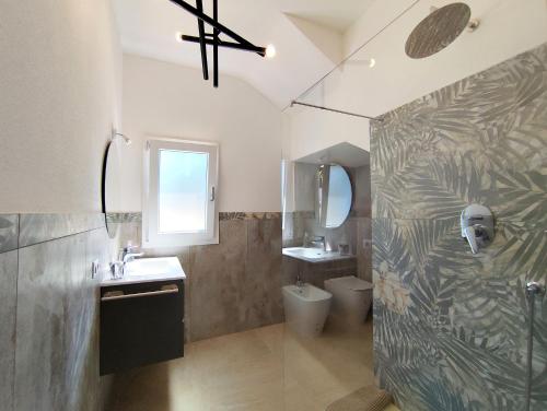 a bathroom with a shower and a sink and a toilet at Villa il borgo con piscina in Budoni