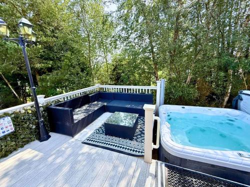 a jacuzzi tub on a deck with a street light at Lovely Hot Tub Caravan in Northumberland, Free Golf Access, Dog Friendly in Swarland