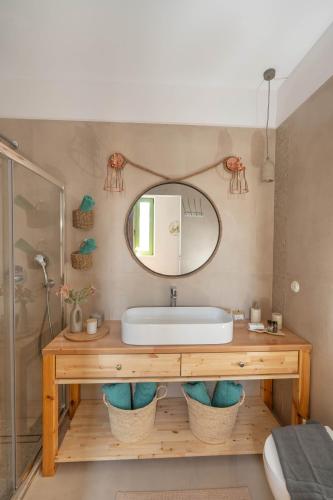 a bathroom with a sink and a mirror at Villa Emerald in Koskinou