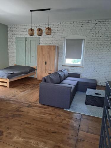 a living room with a couch and a bed at Stary Młyn in Glinik