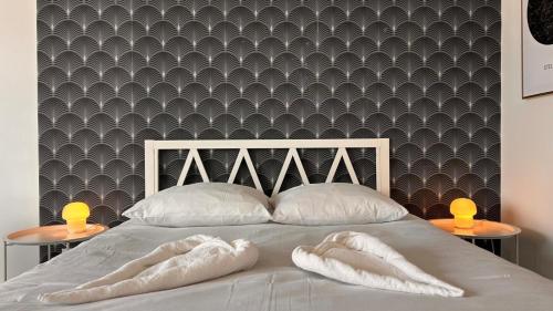 a bedroom with a bed with two white towels at Le Majestueux Calme Central Chic in Le Creusot