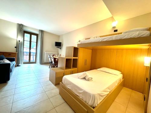a bedroom with two bunk beds and a living room at Hostdomus - Stella Alpina in Pragelato