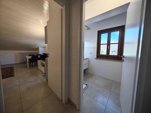 a hallway with a room with a table and a window at Hostdomus - Stella Alpina in Pragelato
