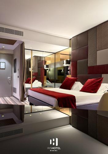 a bedroom with two beds with red pillows at Iris Hotel in Erbusco
