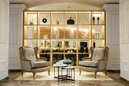 two chairs and a table in a room with shelves at Midtown Boutique Hotel in Buenos Aires