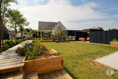 a backyard with a wooden deck with a garden at Ti ma zud 2 in Plestin-les-Grèves