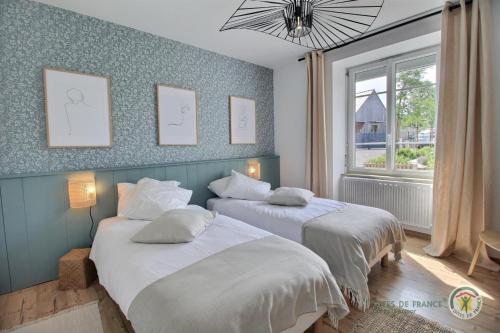 a bedroom with two beds and a window at Ti ma zud 2 in Plestin-les-Grèves