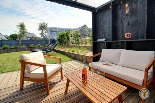 a patio with a couch and chairs on a wooden deck at Ti ma zud 2 in Plestin-les-Grèves