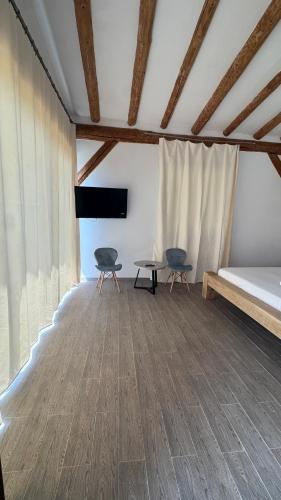 a room with two chairs and a bed and a table at Pensiunea Poiana Izvoarelor in Vatra Dornei
