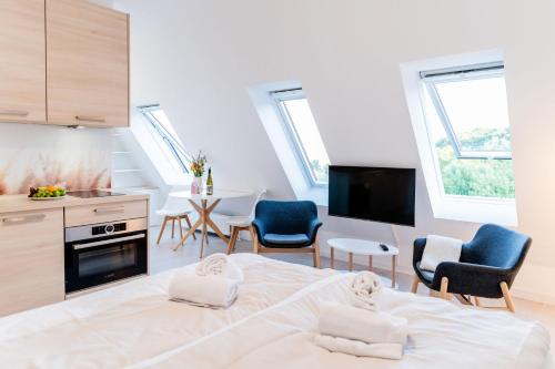 a bedroom with a bed and chairs and a kitchen at Pure Hygge in Harrislee