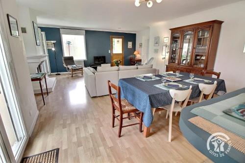 a dining room and living room with a table and chairs at Ker hevoudek in Étables-sur-Mer