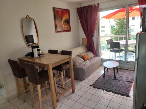 a living room with a table and a couch at Le Thalassa I appartement T2 en bord de plage et du Port in Gruissan