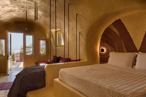 a bedroom with a bed in a large room at Canyon Santorini in Fira