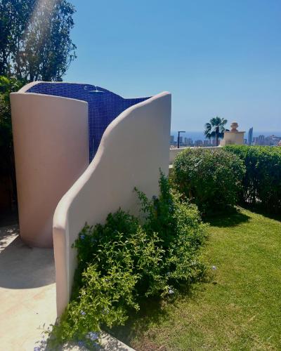 a white bench sitting on top of a grass field at Exclusive house in Finestrat in Cala de Finestrat