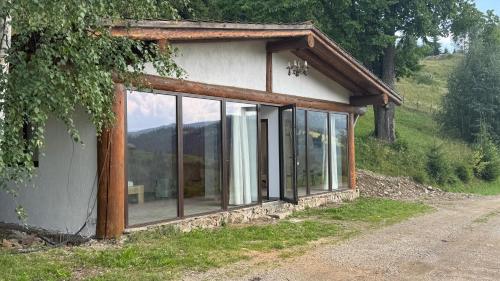 a small house with glass windows on a hill at Pensiunea Poiana Izvoarelor in Vatra Dornei