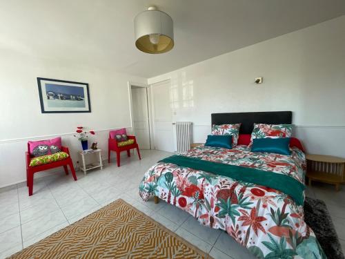 a bedroom with a large bed and two chairs at Cosy one bedroom flat with terrace in Saint-Lunaire