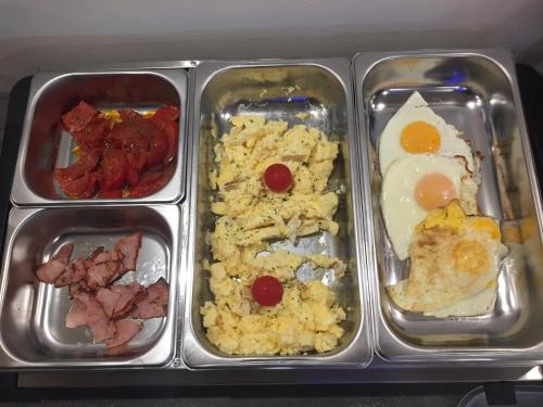 ein Tablett mit Eiern, Fleisch und Reis in der Unterkunft Wellness Hotel TREZOR in Pécs