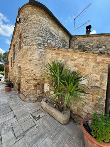 a brick wall with potted plants on a patio at Torre di Viepri in Serre di Rapolano
