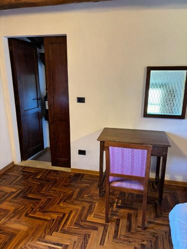 a room with a wooden table and a chair at Torre di Viepri in Serre di Rapolano