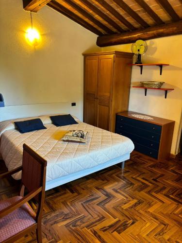 a bedroom with a bed and a wooden floor at Torre di Viepri in Serre di Rapolano