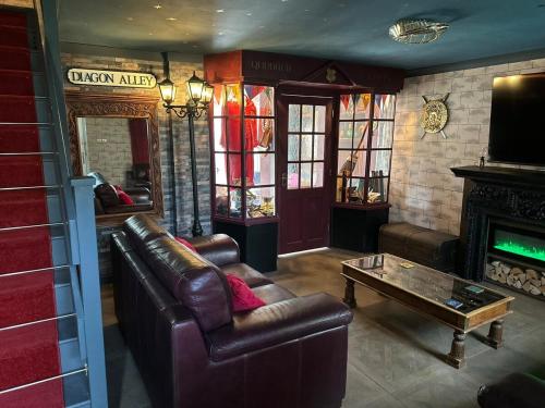 a living room with a leather couch and a coffee table at Quidditch Quarters Themed Property in Garston
