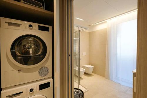 a washing machine in a bathroom with a toilet at Blue Eagle - Villafranca Verona in Villafranca di Verona
