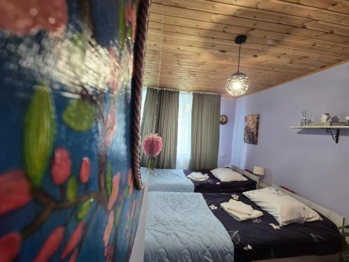 a bedroom with two beds and a painting on the wall at Lemona in Stepantsminda