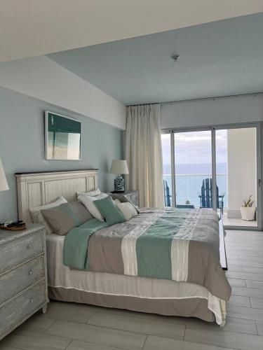 a bedroom with a bed with a view of the ocean at Beachfront FL21 Con Tina Aquarella in La Puntica de Juan Dolio