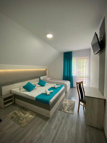 a bedroom with two beds and a chair and a television at Casa Alberto in Sovata