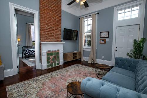 ein Wohnzimmer mit einer blauen Couch und einem Kamin in der Unterkunft St Philip Gem 5 Bed-5 Bath Steps to FQ - Monthly in New Orleans