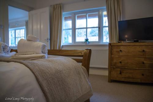 a bedroom with a bed and a flat screen tv at The Dairy Cottage, Loch Tay, Hot Tub and Garden in Lawers