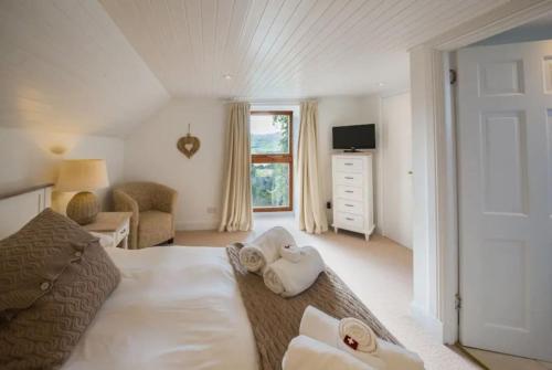 ein Schlafzimmer mit einem Bett mit zwei Handtüchern darauf in der Unterkunft The Barn on Loch Tay - Hot Tub in Lawers