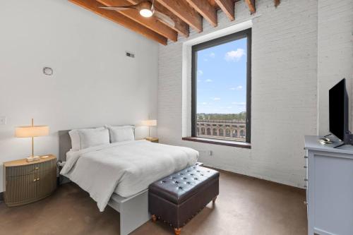 a white bedroom with a bed and a window at Brick & Bed, Riverfront Lofts, P 4J in Saint Louis