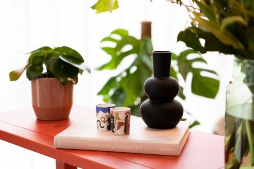 a black vase sitting on a book on a table at B&B HOTEL Brussels Airport in Diegem