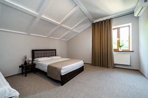a bedroom with a large bed and a window at Villa Caza in Chişinău