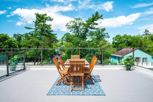 a wooden table and chairs on a patio at The Perch 14 on Front 2BR Private Hot Tub Patio Downtown Walks in Traverse City