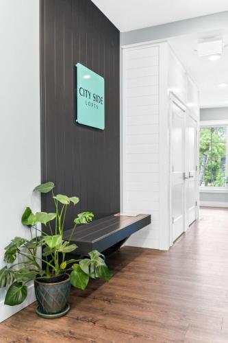 a black bench in a room with a sign on a wall at The Perch 14 on Front 2BR Private Hot Tub Patio Downtown Walks in Traverse City