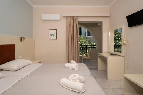 a hotel room with two towels on a bed at Karras Livin in Laganas