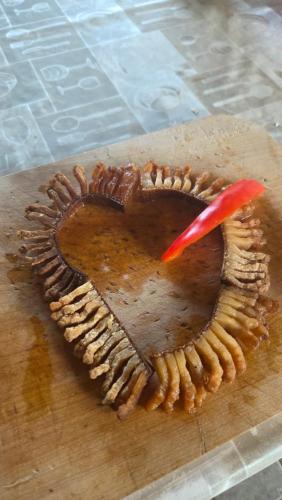 a heart shaped cake with a red candle on a cutting board at Pensiunea Natura Sadu in Sibiu