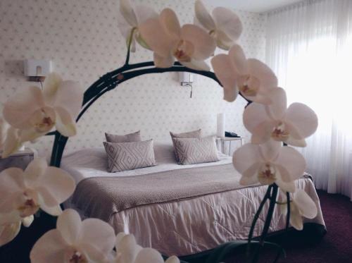 Un dormitorio con una cama con flores blancas. en Relais Du Vignoble en Gueberschwihr
