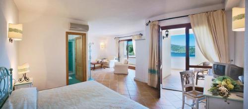 sypialnia z dużym łóżkiem i salonem w obiekcie Hotel Valkarana Country Relais w mieście Sant Antonio Di Gallura