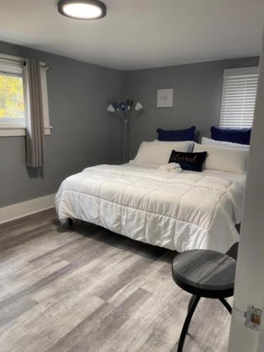 a bedroom with a large white bed and a chair at N Lake Ontario 3BR Home Near Beach Seabreeze in Rochester