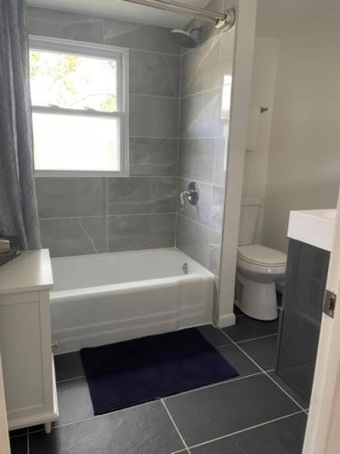 a bathroom with a white tub and a toilet at N Lake Ontario 3BR Home Near Beach Seabreeze in Rochester