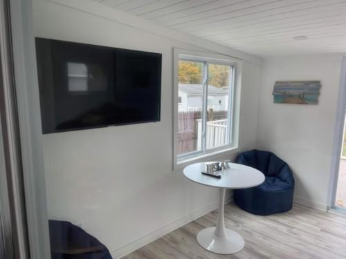 a room with a table and a tv and a window at N Lake Ontario 3BR Home Near Beach Seabreeze in Rochester